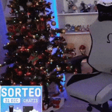 a person sitting in a chair in front of a christmas tree next to a sign that says sorteo