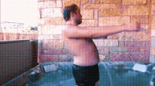 a shirtless man is standing in a hot tub