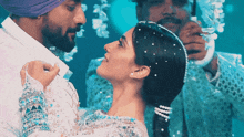 a man in a turban and a woman in a white dress are dancing