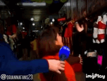 a woman is being interviewed by a man with a microphone and a watermark that says imgplay on the bottom