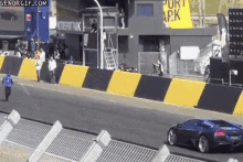 a car is driving down a race track with a sign that says port apk on it