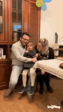 a man and a woman are holding a little girl in their arms