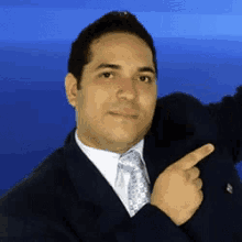 a man in a suit and tie is pointing to the right