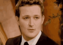 a man in a suit and tie is looking at the camera