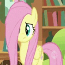 fluttershy from my little pony is standing in front of a bookshelf in a library .