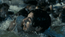 a group of people are swimming in a pool and a woman is laying in the water .