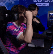 a man wearing headphones is sitting in front of a sign that says masters toronto