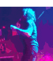 a man is singing into a microphone on a stage in a club .