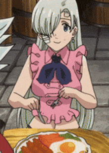 a girl in a pink dress is sitting at a table with a plate of food on it .