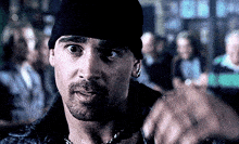 a man with a beard wears a black beanie