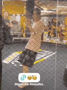 a person behind a chain link fence with a sticker that says @boss.ckm @noeullee on it