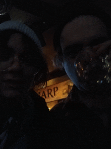 two people standing in front of a sign that says arp on it