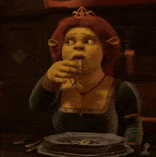 shrek 's fiona is sitting at a table with plates and a glass of wine