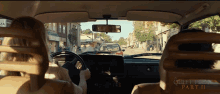 a movie poster for quiet place part ii shows a woman driving a car down a street