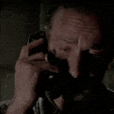 a man with a ring on his finger is covering his nose while talking on a phone