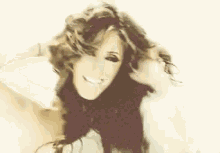 a woman with long hair is smiling and looking at the camera .