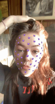 a girl with purple smiley faces on her face is wearing a black shirt that says '11