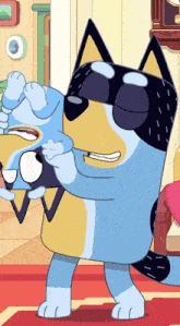 a blue and yellow cartoon dog is holding a baby