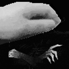 a black and white photo of a person 's hand reaching out towards the camera .