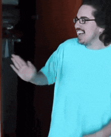 a man wearing glasses and a light blue shirt