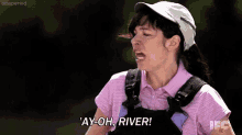 a woman wearing a pink shirt and overalls is shouting .