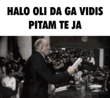 a man is giving a speech in front of a crowd with the words halo oli da ga vidis pitam te ja