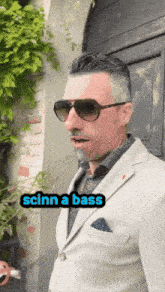 a man in a suit and sunglasses says scinn a bass in a sticker
