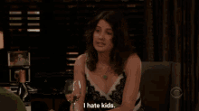 a man is sitting at a table with a glass of wine and says i mean i don 't hate kids