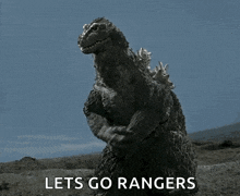 a monster says let 's go rangers in front of a blue sky