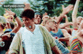 a man is dancing in front of a crowd of people at a party .