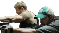 a man in a green hat is holding a gun next to another man