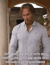 a man in a striped shirt is standing in front of a sign that says ging qui s'appelle a sortir son