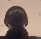 a woman wearing a mask and a ponytail is looking at the camera .