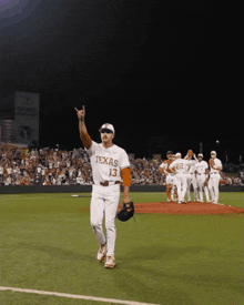a man wearing a texas jersey is walking on the field