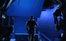 a man stands in front of a blue wall