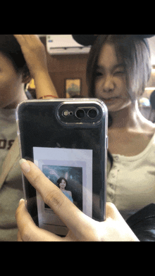 a woman is taking a picture of herself in a clear phone case