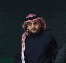 a man with a beard wearing a head scarf