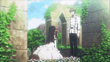 a man and a woman are standing next to each other in a garden with flowers .