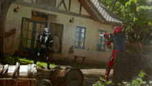 a man in a red and black costume is holding a gun in front of a house