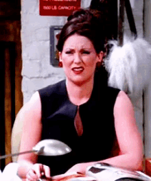 a woman in a black dress is sitting in front of a sign that says 500 lbs capacity