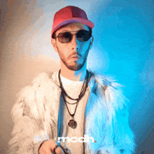 a man wearing sunglasses and a fur coat has the word mcdh on the bottom right