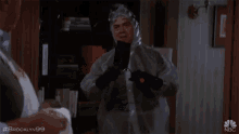 a man in a protective suit is talking to another man with the hashtag #brooklyn99