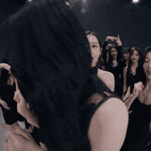 a group of young women are dancing together in a dark room