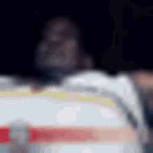 a blurry picture of a person standing in front of a white vehicle .