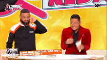 a man in a red jacket is standing next to another man in a black jacket
