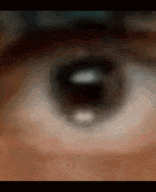 a close up of a person 's eye with a blurred image