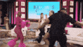 a group of people are dancing in front of a screen that says baddies 2