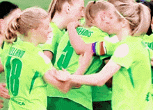 a group of female soccer players hugging each other with one wearing a number 18 jersey
