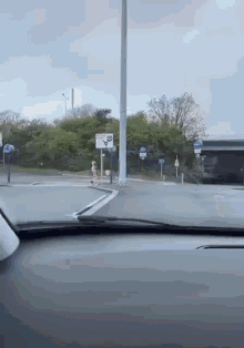 a car is driving down a street with a sign that says ' a ' on it .