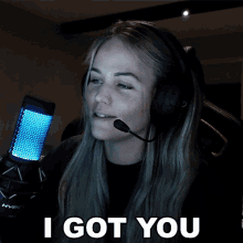 a woman wearing headphones says " i got you " in front of a microphone